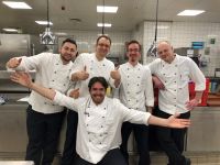 Danil Kretschmann kniend vor „seinem“ Küchenteam, der stolze Küchenchef Uwe Range stehend hinte ihm 